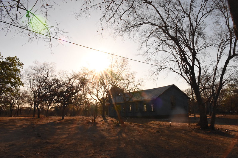 Sun shining down on a building in a rural landscape with trees in Zimbabwe