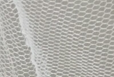 Piece of white mosquito net with dark beige background